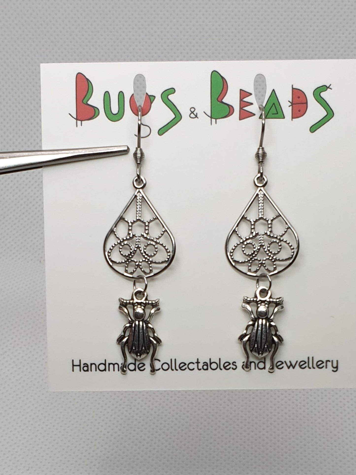Tiny ground beetle on drop earrings