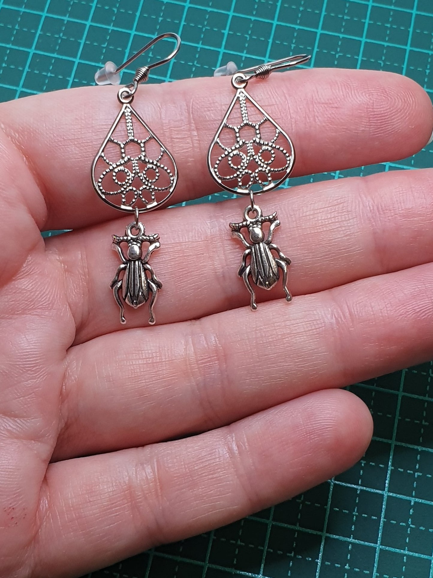 Tiny ground beetle on drop earrings
